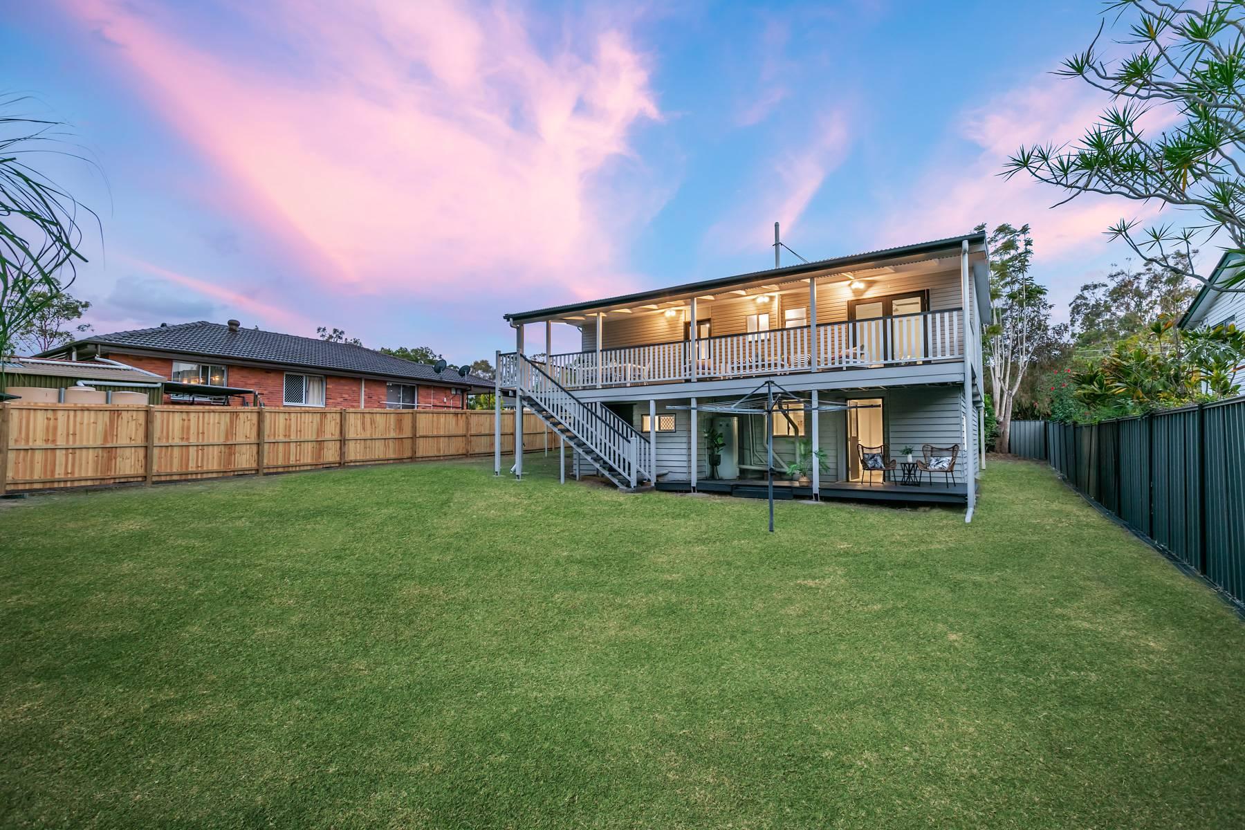 Rear yard and two-level house at dusk, Woodridge renovation